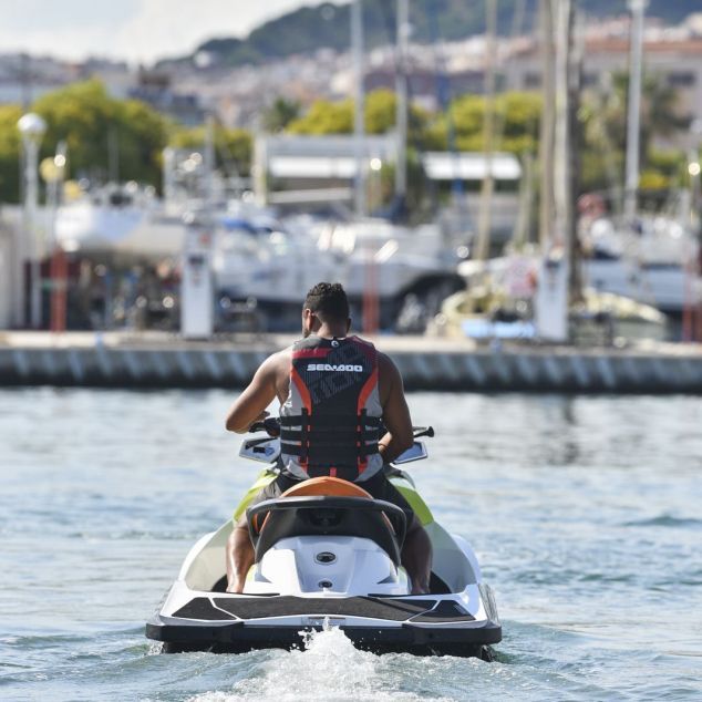 Fahrer mit Schwimmweste startet mit dem Jetski im Hafen von Mataró